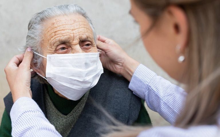 Doctor helping patient with mask